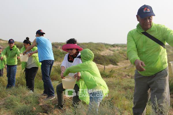 日立建机公益林志愿者植树完毕集体进行浇水
