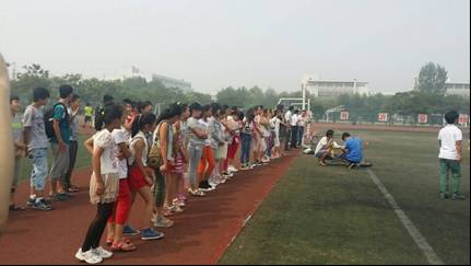 希望小学毕业生在操场观看模型飞机表演