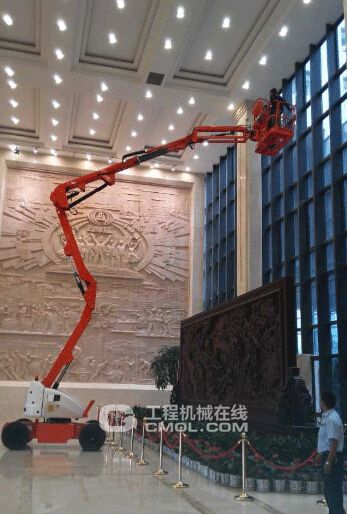 工作人员正使用电动曲臂式高空作业平台对墙体玻璃进行清洗