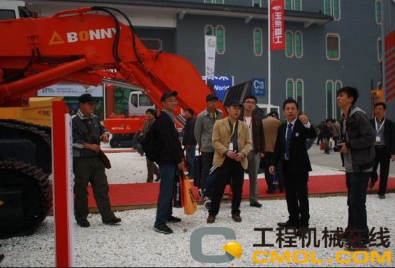 玉柴重工参展工作人员为中国工程机械行业网站大型参观团介绍公司新机型的情景