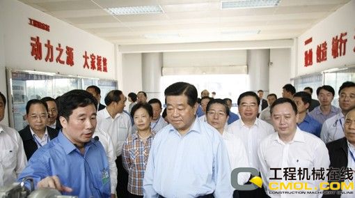 晏平（左一）向贾庆林主席（前排右三）介绍玉柴发动机