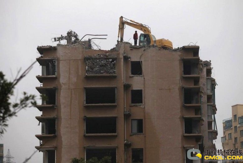 2011年12月6日，浙江台州玉环“台州地区最大纯海景住宅小区”渝汇蓝湾国际小区内，挖机正在拆除一幢18层高的小区建筑。图为挖机正在拆迁。