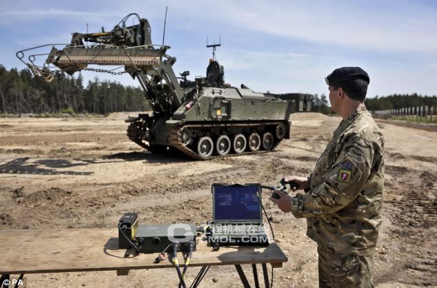 一个士兵使用游戏控制台风格的控制器操纵这种被称为Terrier装甲挖掘机 